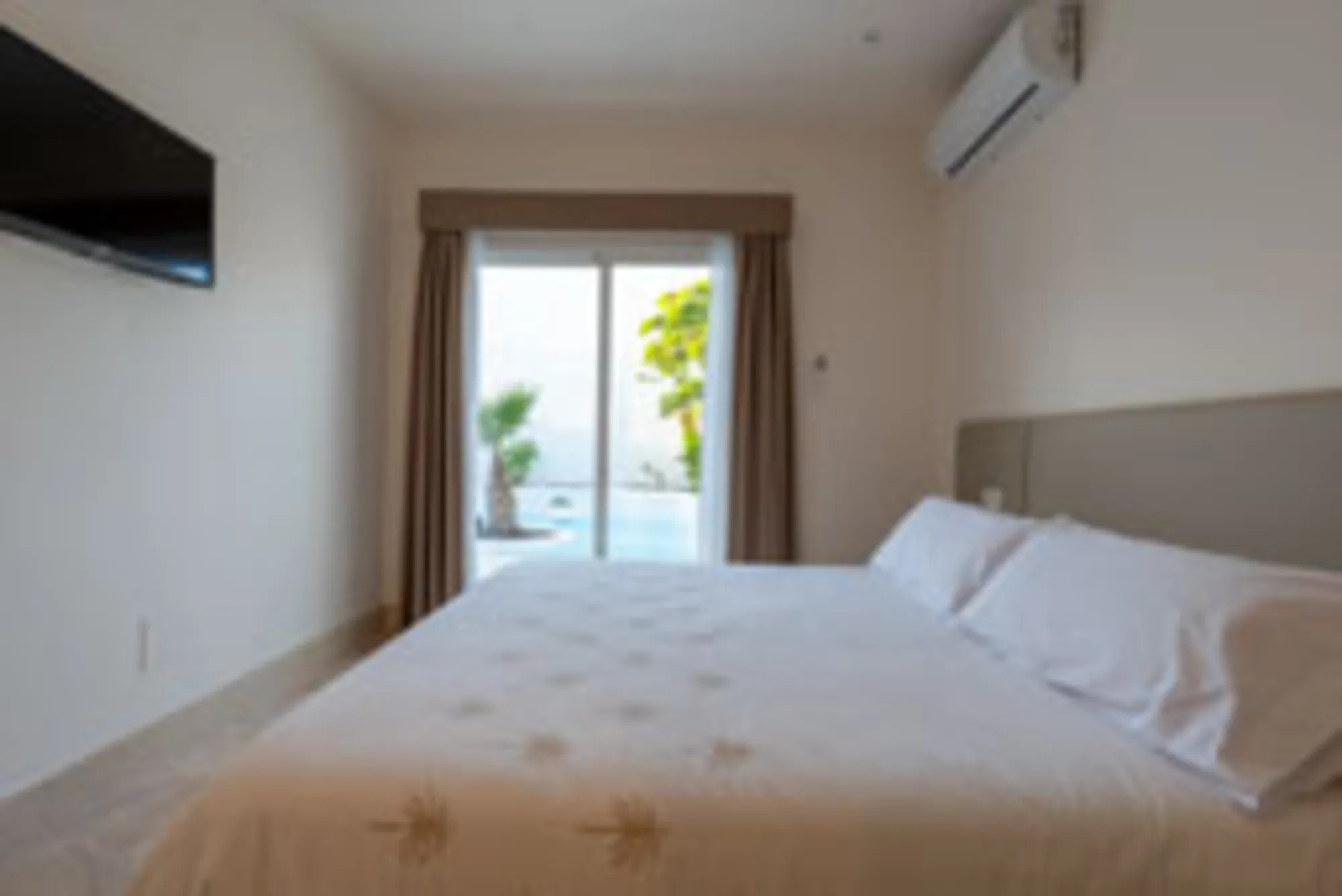 Habitación 3 con cama king y acceso al jardín con piscina