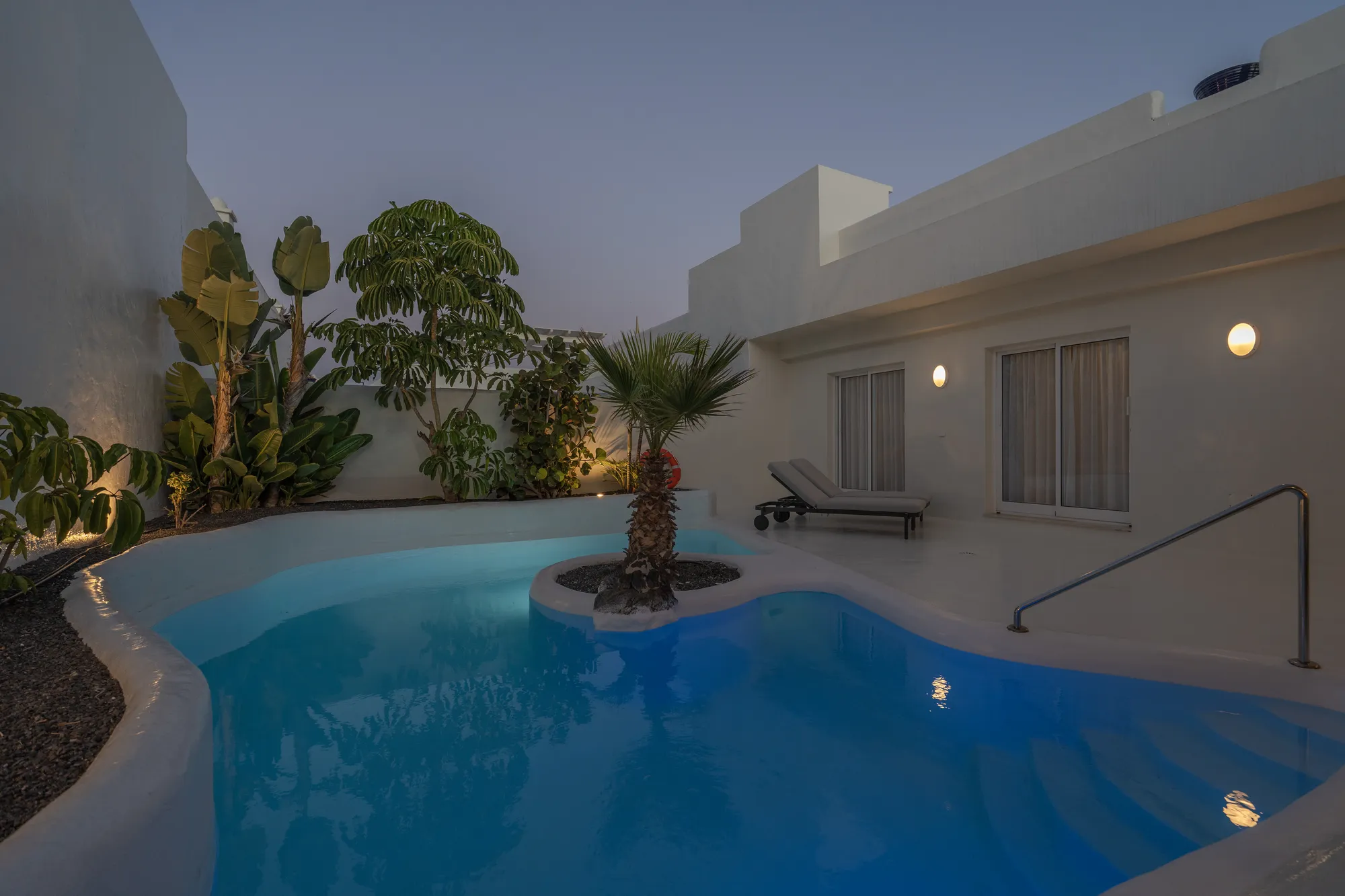 Vista de la piscina privada con sofás exteriores