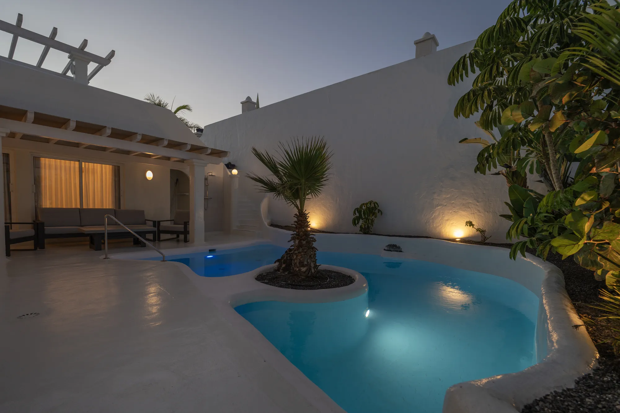 Vista de la piscina privada climatizada de Villa Blue Bay al atardecer